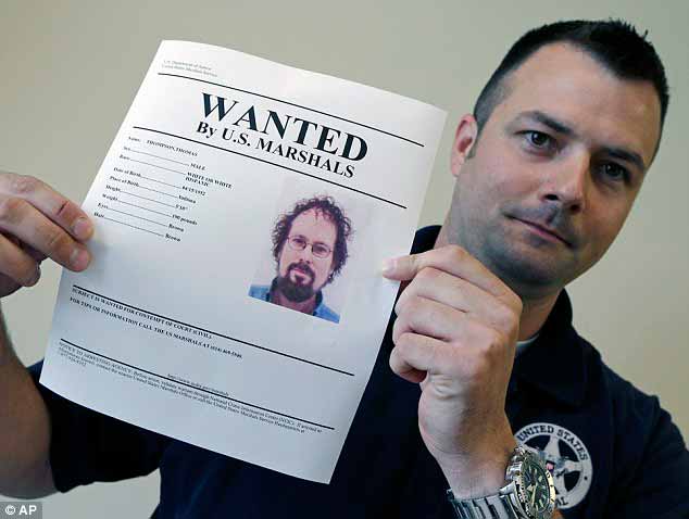 Un Marshal de Ohio posando con el cartel de Se Busca de Tommy Thompson, fuente Dailymail.co.uk